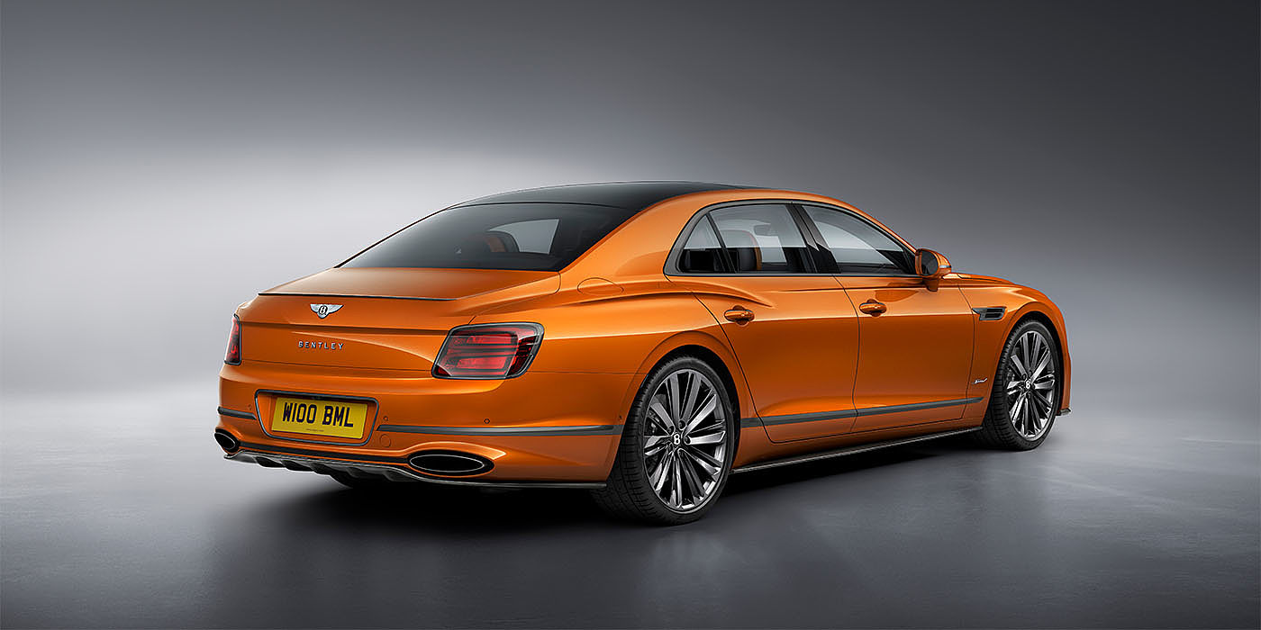 Bentley Brussels Bentley Flying Spur Speed in Orange Flame colour rear view, featuring Bentley insignia and enhanced exhaust muffler.