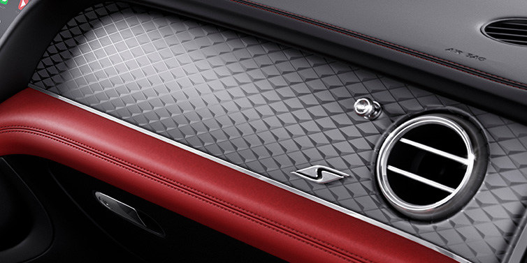 Bentley Brussels Bentley Bentayga S SUV front interior dash with Dark Tint Diamond Brushed Aluminium veneer and S badge surrounded by Hotspur red and Beluga black hide