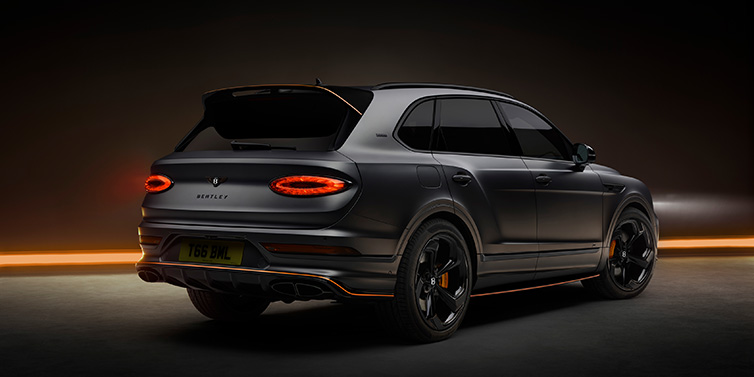 Bentley Brussels Bentley Bentayga S Black Edition SUV rear three quarter in Anthracite Satin paint against a dark red and yellow background