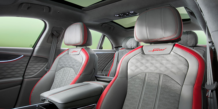 Bentley Brussels Bentley Flying Spur Speed sedan interior showing front and rear seats in Hotspur red and Gravity Grey hides, with Speed seat emblems