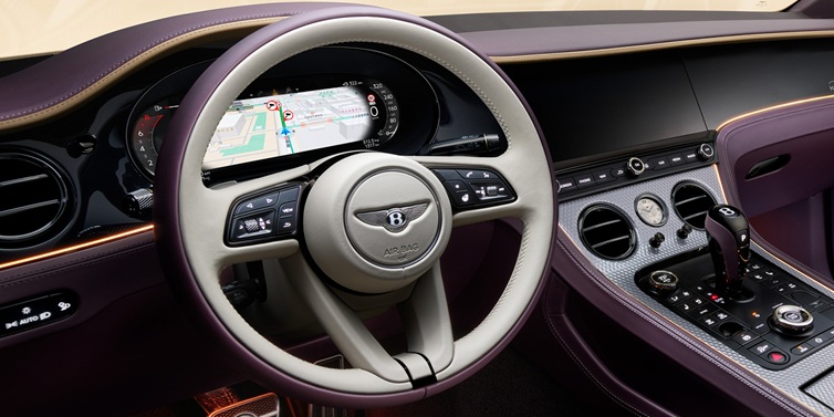 Bentley Brussels Bentley Continental GT Mulliner coupe front interior showing steering wheel and drivers screens surrounded by Linen and Damson hides and Grand Black veneer